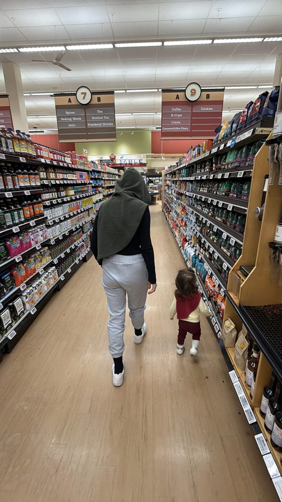 Lauren and Mila walking down the grocery aisle
