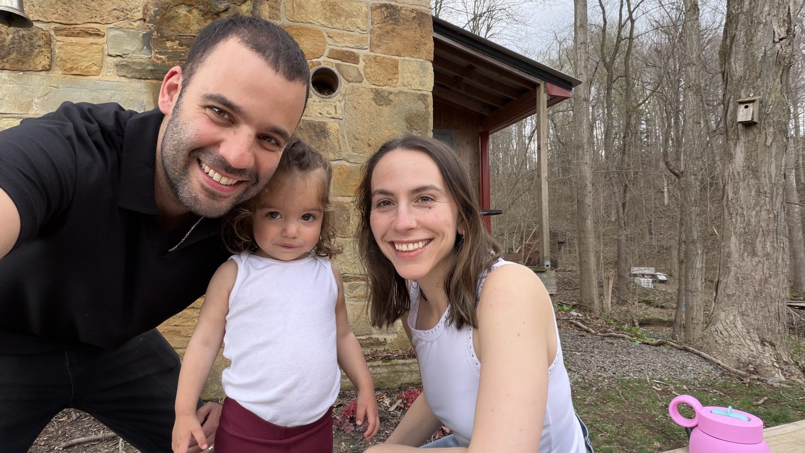 Family selfie with Dad, Mila, and Lauren outside the stone cabin