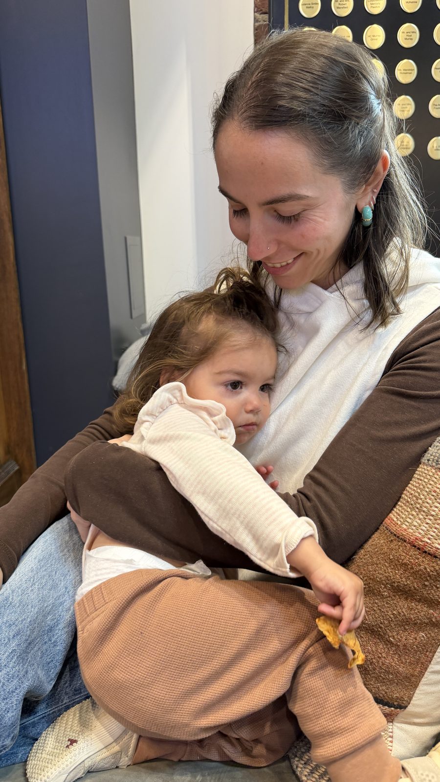 Lauren holding Mila who is curled into her