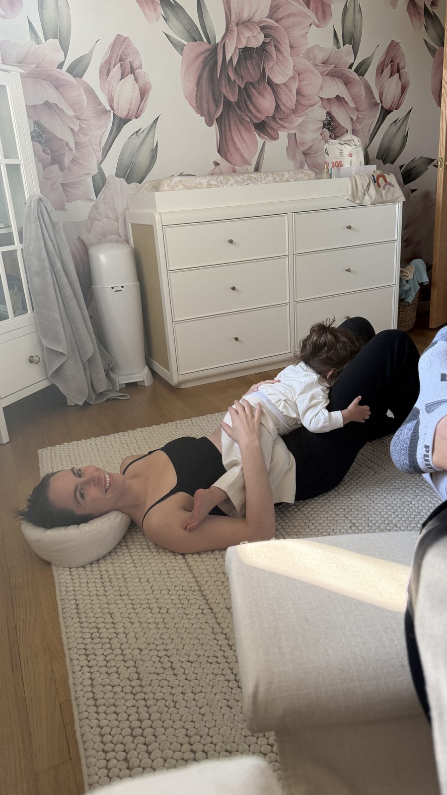 Lauren laying on the nursery floor laughing